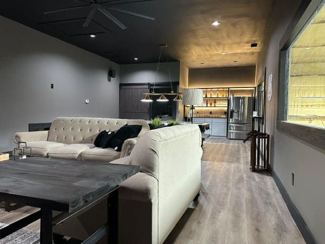 Modern interior of a stylish living space with a beige sofa, dining table, and kitchen view.