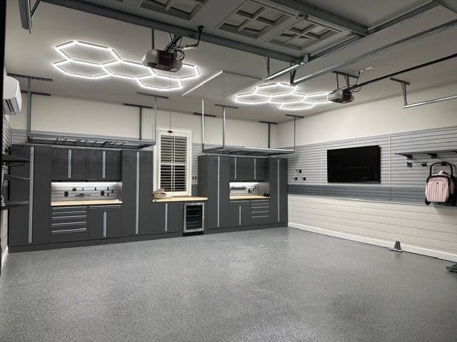 Modern garage with sleek cabinetry, hexagonal lighting, and polished concrete floors.