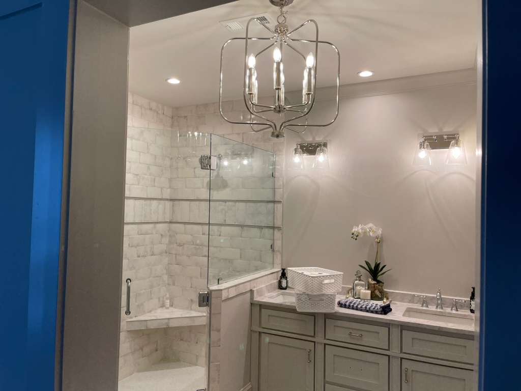Modern bathroom design with glass shower, elegant lighting, and stylish decor accents.