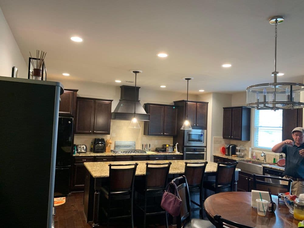 Modern kitchen with dark wood cabinets, granite countertops, and stainless steel appliances.