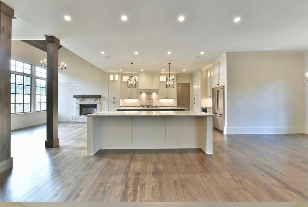 Spacious modern kitchen with granite island, pendant lights, and open floor plan.